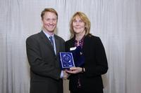 DEK’s Global Marcom Director, Karen Moore-Watts, accepts the NPI Award from Circuits Assembly’s Mike Buetow